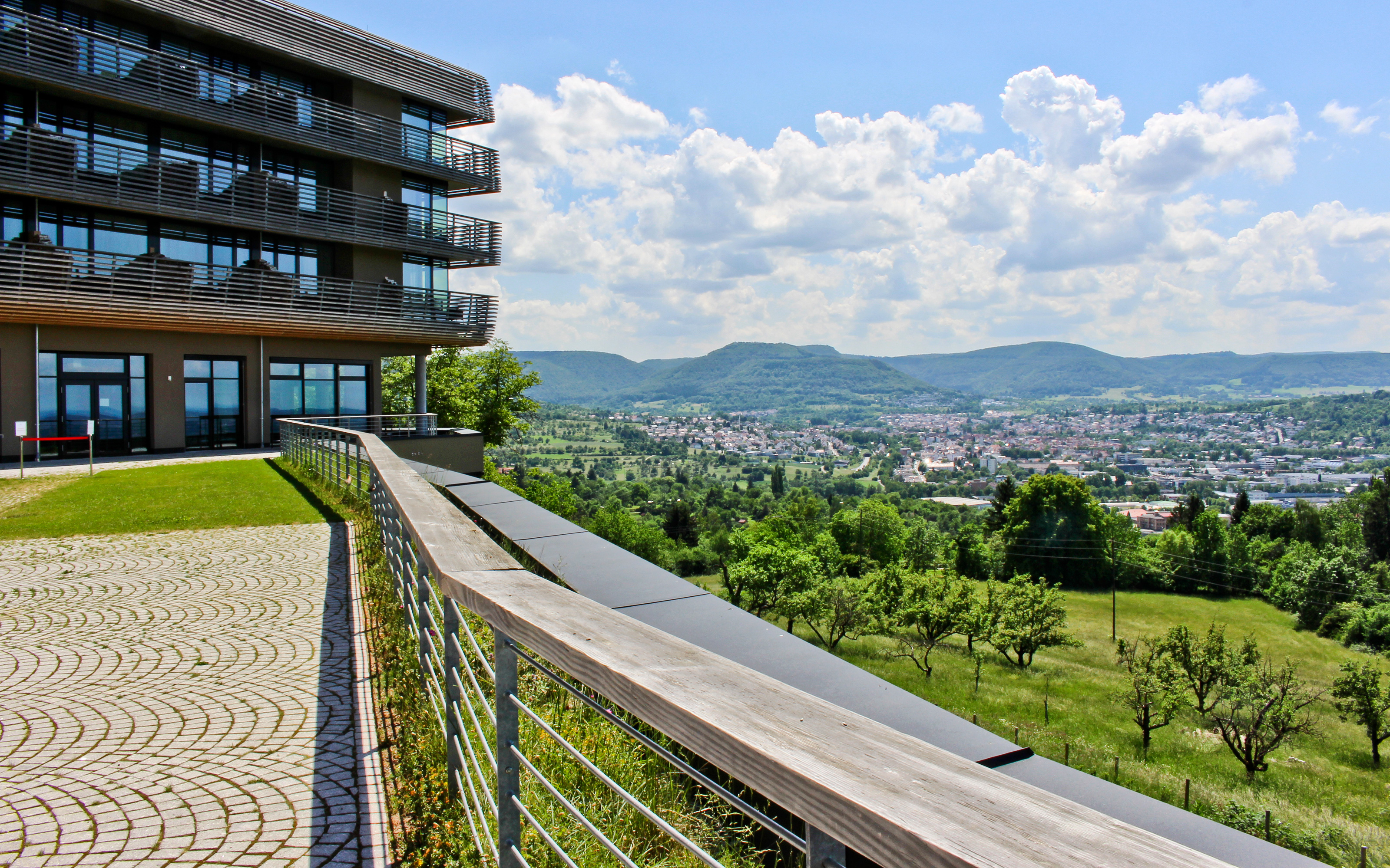 A guardrail provides safe access to the roof garden. Roof garden with natural stone paving and railing